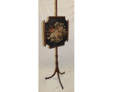 A 19th century mahogany pole screen with floral needlework tapestry panel on turned column with tripod base