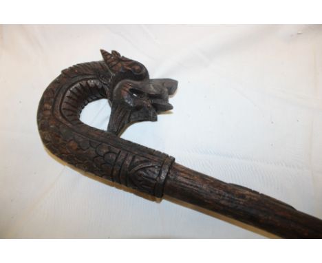 A Chinese carved wood walking stick with dragon head emblem