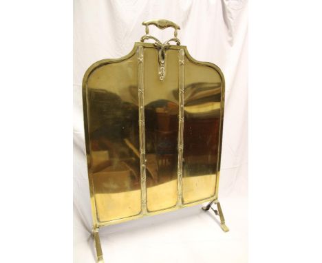 An Edwardian 1920's brass arched fire screen with loop handle, 30½" high overall