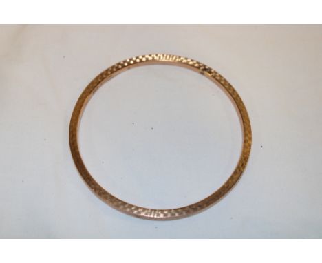 A 9ct gold circular bangle with engraved decoration (6.4g)