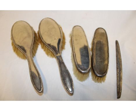 A George V silver dressing set comprising a pair of hair brushes, a pair of clothes brushes and comb back, Birmingham marks 1