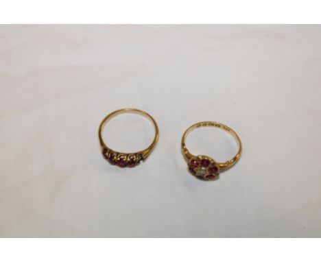 An 18ct gold dress ring set central diamond surrounded by six rubies (2.3g) and an unmarked gold dress ring set red stones (2