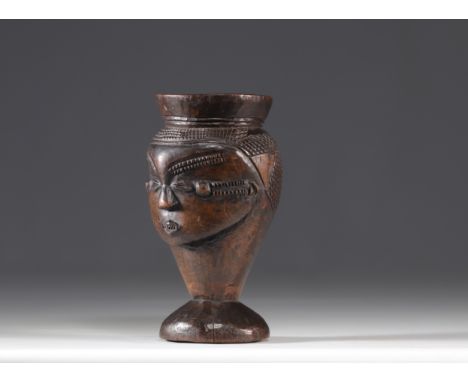 This Kuba palm wine cup, decorated with a head, is a rare and precious piece. It was carved in the early 20th century by an u