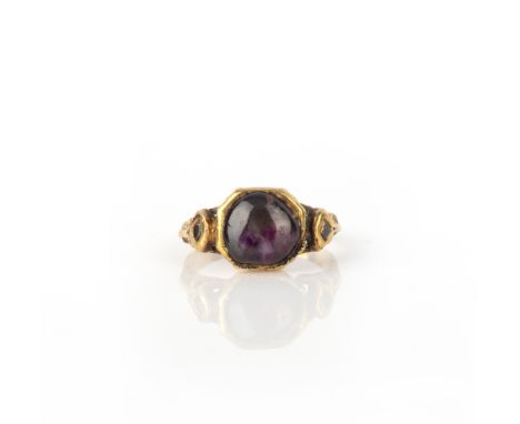 A ruby and diamond ring, India, set with a cabochon ruby the shoulders set with lasqué diamonds, mounted in gold, decorated w