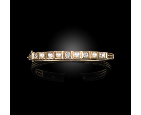 A late 19th century pearl and diamond bangle, alternately-set with cushion-shaped diamonds and half pearls in yellow gold, in
