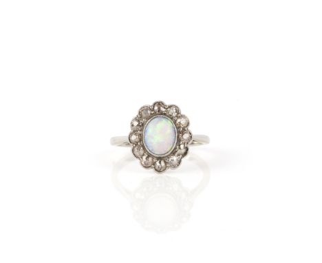 An opal and diamond cluster ring, the white opal set within a surround of old cushion-shaped diamonds in platinum and white g