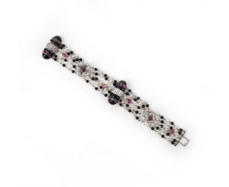 An gem-set, pearl and diamond bracelet, composed of two half cylinders of carved onyx, set with lines of calibré-cut rubies a