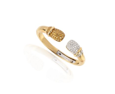 A gem-set gold hinged bangle, of hinged torque design, the terminals pavé-set with brilliant-cut diamonds and circular-cut ye