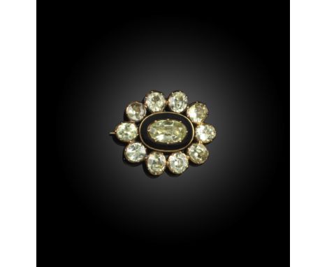A late Georgian chrysoberyl and enamel mourning brooch, circa 1827, of oval outline, designed as a cluster of oval chrysobery