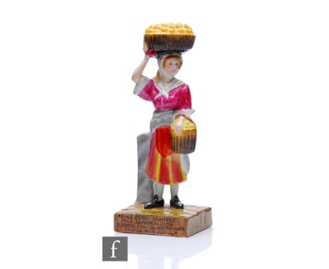 Clarice Cliff - The Orange Seller - A figure modelled as a market seller with a basket of oranges on her head and another on 
