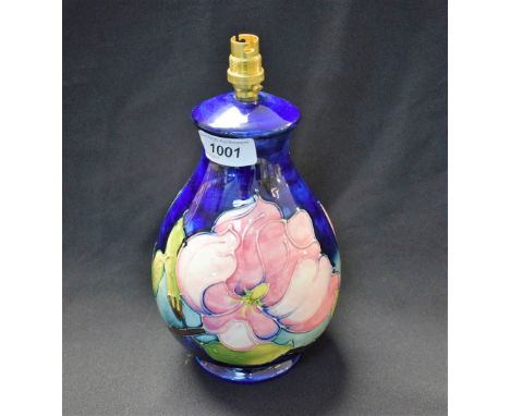A Moorcroft Magnolia pattern baluster table lamp, applied with large pink flowers and slender leafy branches on a cobalt blue