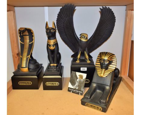 A modern Egyptology ceramic model of a Sphynx, Sovereign of the Nile, glazed in black picked out in gold; three others simila