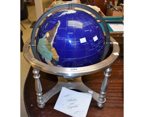 A large globe, inlaid semi-precious stones, brushed steel stand with compass