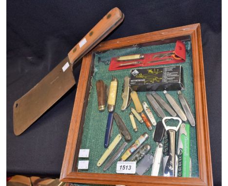 A pen knife, other pocket knives, multi-tool with various accessories, in a glass table top display case; a military cleaver,