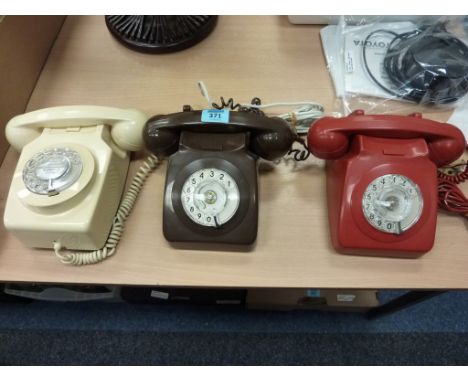 Three vintage plastic rotary dial telephones (red, brown, cream)
