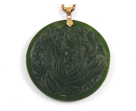 A carved Chinese nephrite jade pendant, 6.3cm diameter, with 18 carat gold bale and 9 carat gold chain. Chain approx. 15.9gms