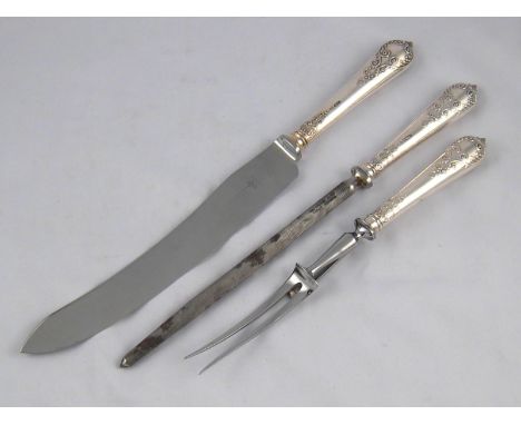 A matched silver handled carving set of knife, fork and steel, knife and steel Sheffield 1946, fork Sheffield 1975.
