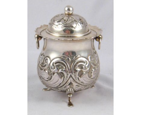 A silver tea caddy with ring handles, shell and pad feet and embossed scrolling decoration, by William Devenport, Birmingham,