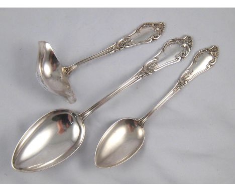 Three matching German 800 assay silver rococo serving pieces; a tablespoon, a serving spoon and a double lipped sauce ladle. 