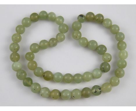 A jade bead necklace, beads approx 14.5mm diameter, 70cm long.
