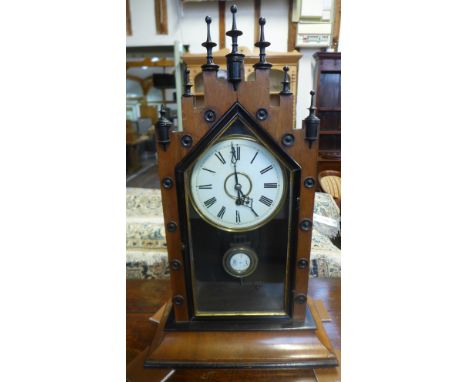 A late 19th century walnut and ebonised Gothic revival mantle clock having painted dial with Roman Numerals and cathedral han