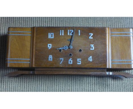 A French Art Deco mahogany cased mantel clock with an eight day movement, Arabic aluminium numbers and trim on a platform bas