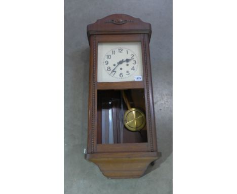 A 1940's oak cased wall clock with a three train movement