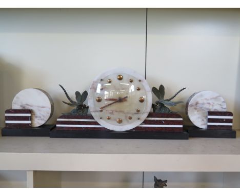An Art Deco marble mantel clock and garnitures with Dragonfly's opposing and flanking dial
Condition report: In good order bu