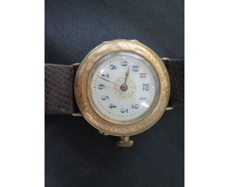 A early 20th century Continental 14K gold watch with cream dial and gilt hands, engine turned case on later strap - Dial 22mm