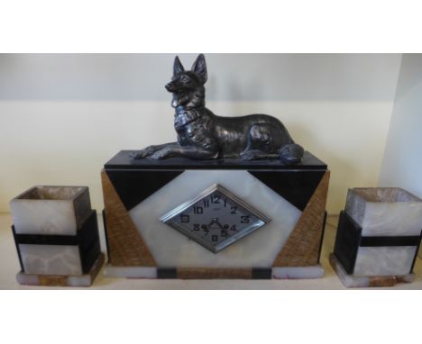 An Art Deco eight day pietre dure garniture clock surrounded by a canine figurine diamond shaped face with Arabic numerals by