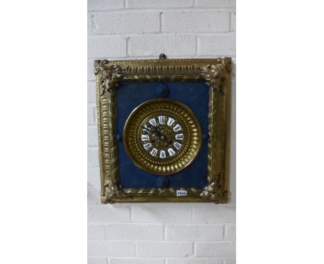 An early 20th century embossed and cast gilt metal mounted wall clock, the moulded rectangular frame, blue fabric inset, bras