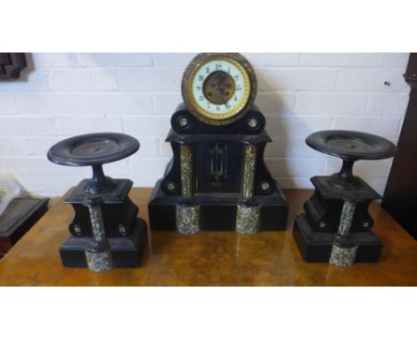 A late 19th century French slate and mottled green marble garniture clock with drum top, visible escapement to the circular p
