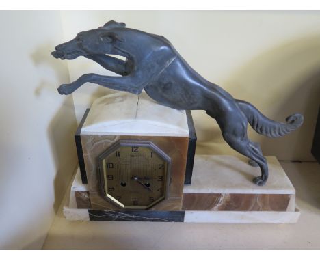 An Art Deco marble mantel clock with Arabic numerals to dial, Spelter dog leaping over movement 
Condition report: Not workin