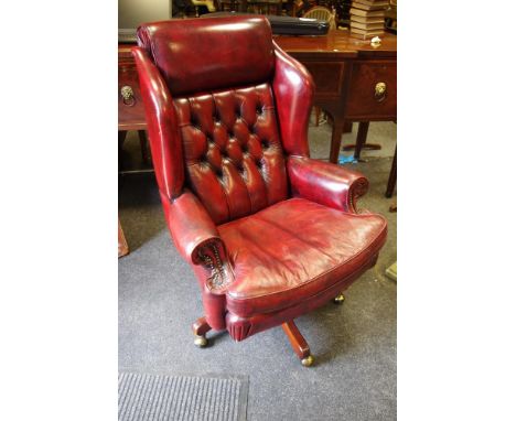 An Ox blood leather wing back office swivel chair, button back scrolling arms squab cushion.Provenance - used by the Lord May
