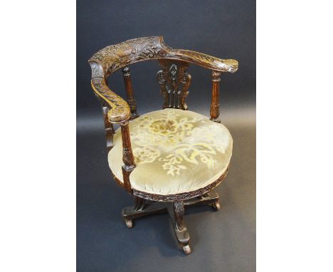 A late 19th century oak office swivel chair, profusely carved with scrolling foliage, upholstered  tapestry seat, acanthus sc