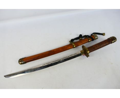 An ornamental wakizashi sword with carved grip with brass mountings, 48 cm (l) blade in brass mounted wooden scabbard, approx