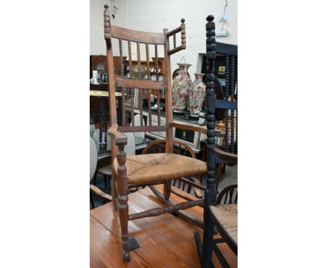 Antique beech framed bobbin back rocking chair with rush seat and turned supports 