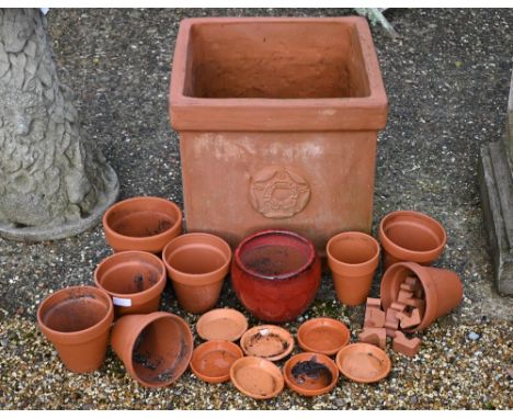 A terracotta square planter with rose motif to/with assorted terracotta plant pots and a weathered reconstituted stone plinth