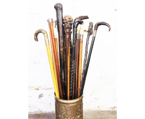 A brass stick stand containing eighteen walking canes, silver top, bone, horn etc.