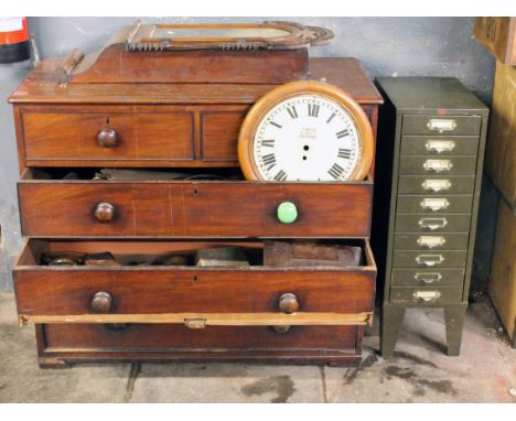 A Victorian chest of drawers and a metal filing cabinet containing various furniture and clock parts together with a wall clo