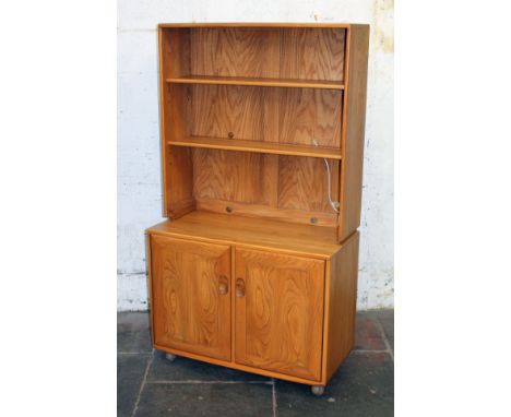 An Ercol light elm and beech cabinet bookcase. W91cm D44cm H163cm