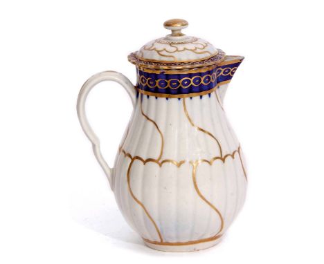Worcester milk jug and cover circa 1780, with a swirling gilt design below a blue gilt border, the cover with similar decorat