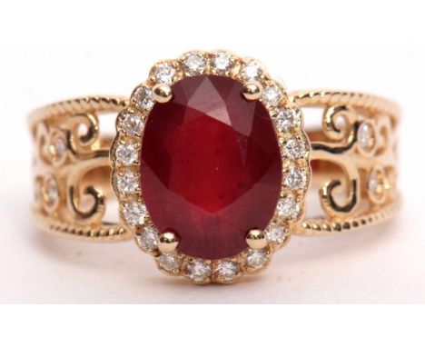 Modern ruby and diamond cluster ring set with an oval cut ruby, 3.10ct (est) within a diamond surround, mount stamped 14K, 0.