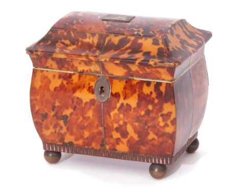 Early 19th century tortoiseshell tea caddy of sarcophagus form, the lifting lid enclosing an interior with two compartments a