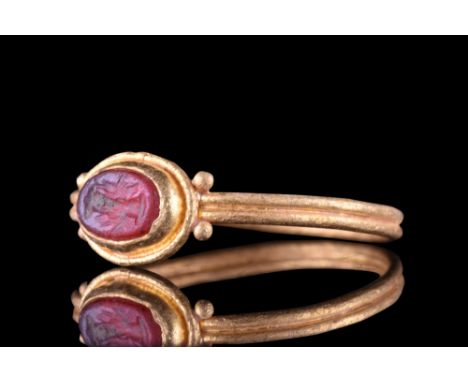 Ca. 1-300 AD. A gold ring with a circular hoop, pairs of fine granules on the shoulders, and an oval-shaped intaglio with a '