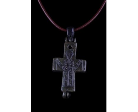Ca. 800-1000 AD. A reliquary cross pendant cast in two separate pieces and hinged at the top and bottom. Both faces are engra