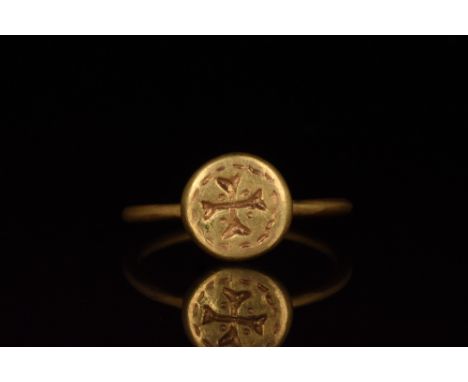 Ca. 1000-1500. A beautiful gold ring with a circular hoop and flattened, discoid bezel bearing an incised Maltese cross withi