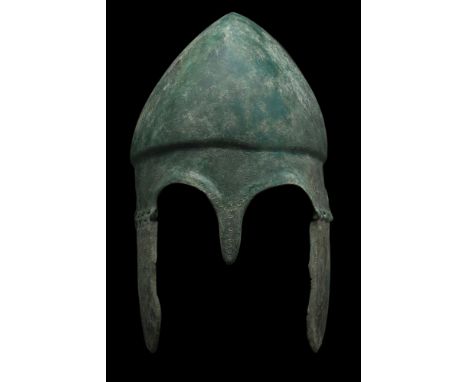 Ca. 500-300 BC. A superb Chalcidian helmet. The bowl is forged in one piece, featuring high-arched eyebrows with an ear drop-