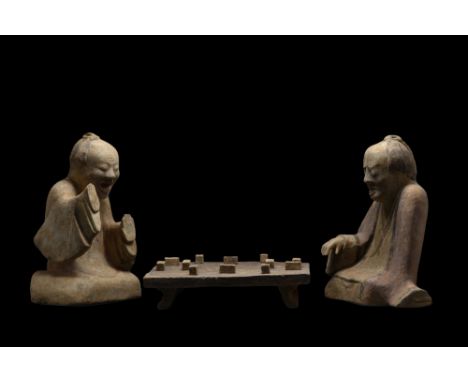 Ca. 206 BC - 220 AD. A set comprising two players and a Liubo board with playing pieces. Both figures are shown in a seated p