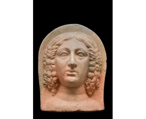 Ca. 400-200 BC. Depicted with her hair arranged in multiple curls, with tresses falling at the sides, a veil drawn up over he